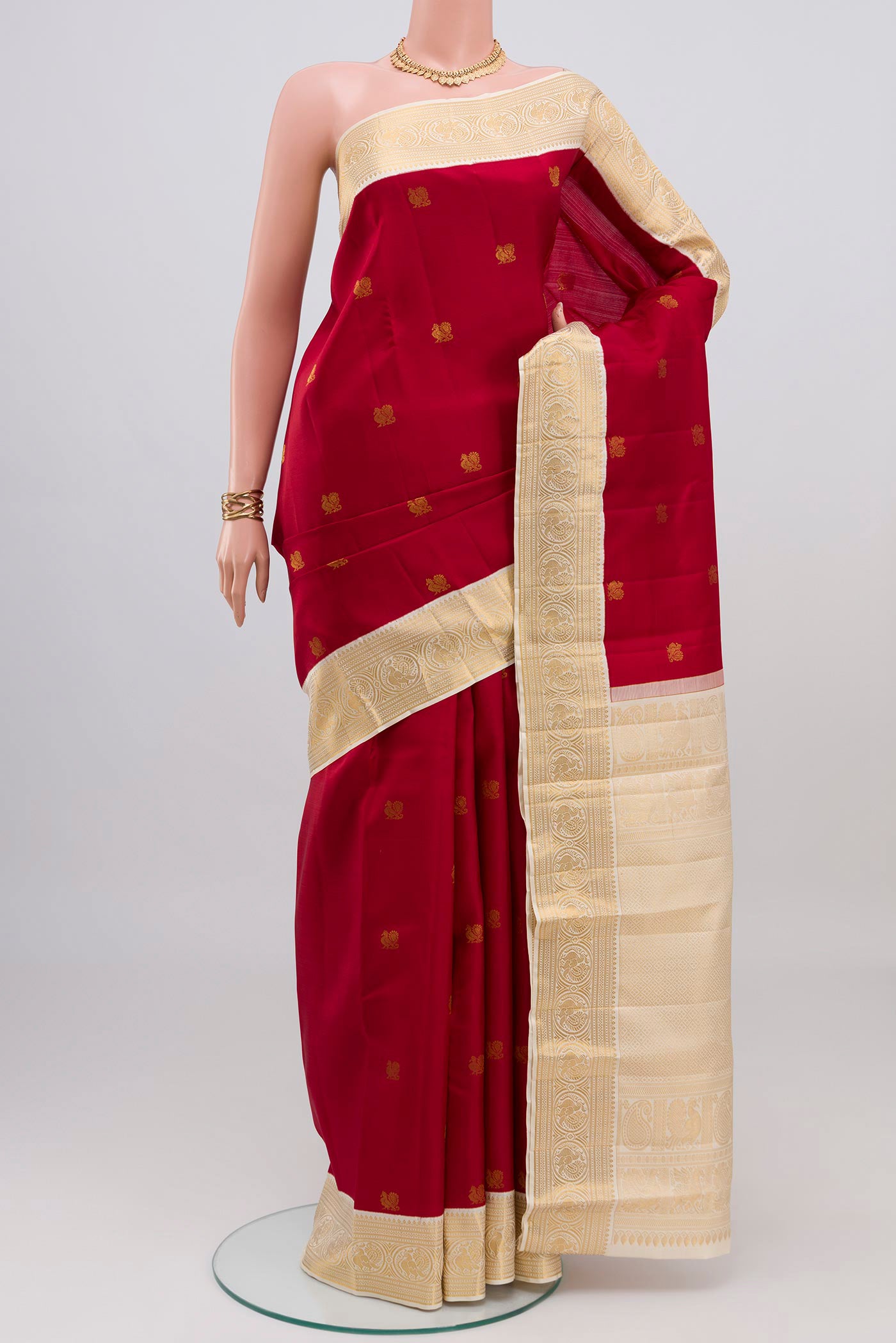 Maroon Kanjivaram Silk Saree with Zari Butta on the body and Zari Border.  displayed on a mannequin