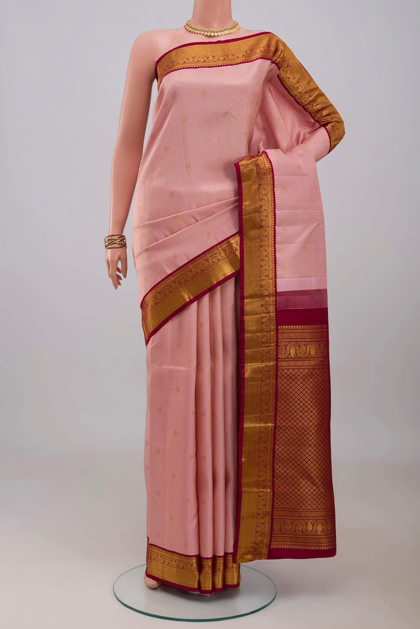 Pink Kanjivaram Silk Saree with Checked design on the body and Zari Border.  displayed on a mannequin