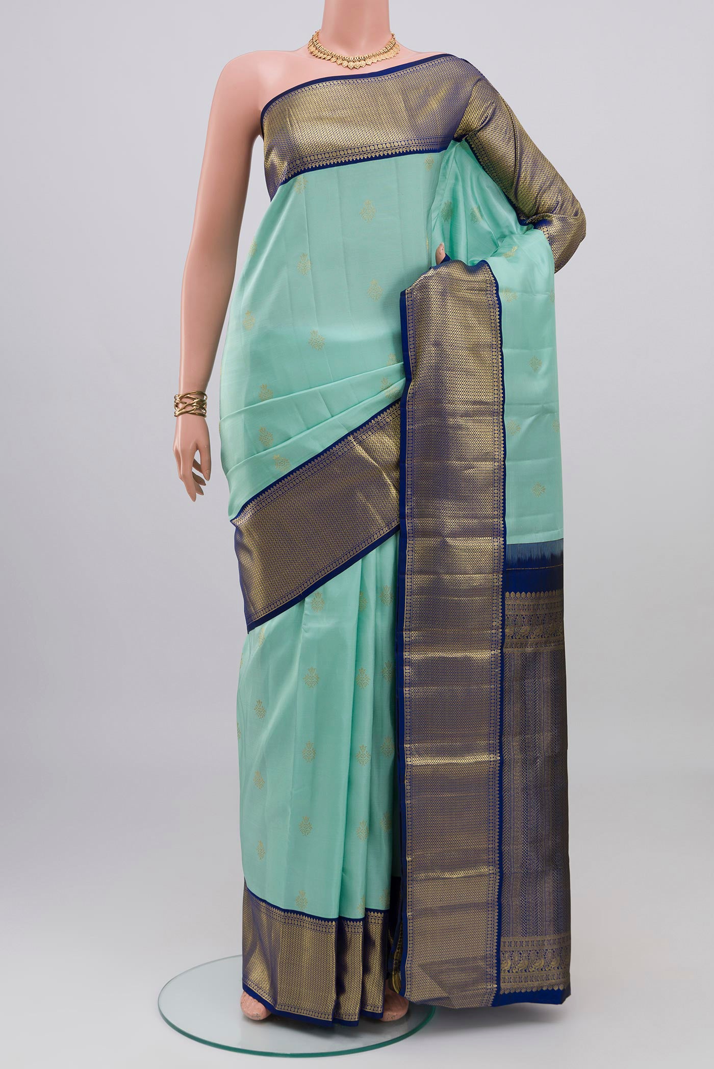 Light Blue Kanjivaram Silk Saree with Zari Butta on the body and Zari Border.  displayed on a mannequin