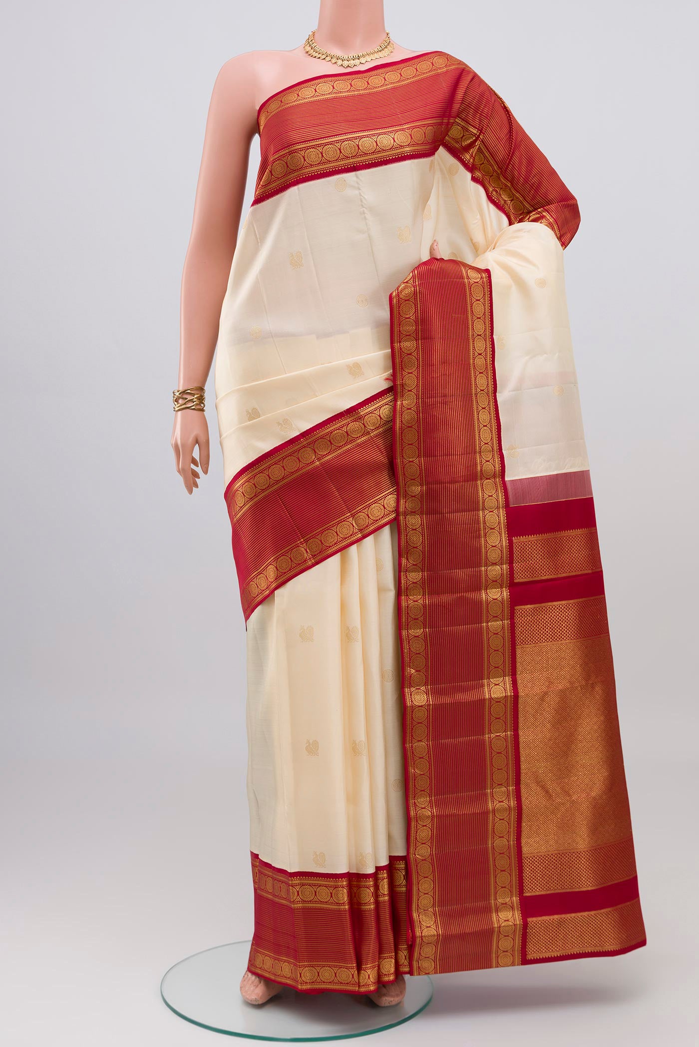 Cream Kanjivaram Silk Saree with Zari Butta on the body and Zari Border.  displayed on a mannequin