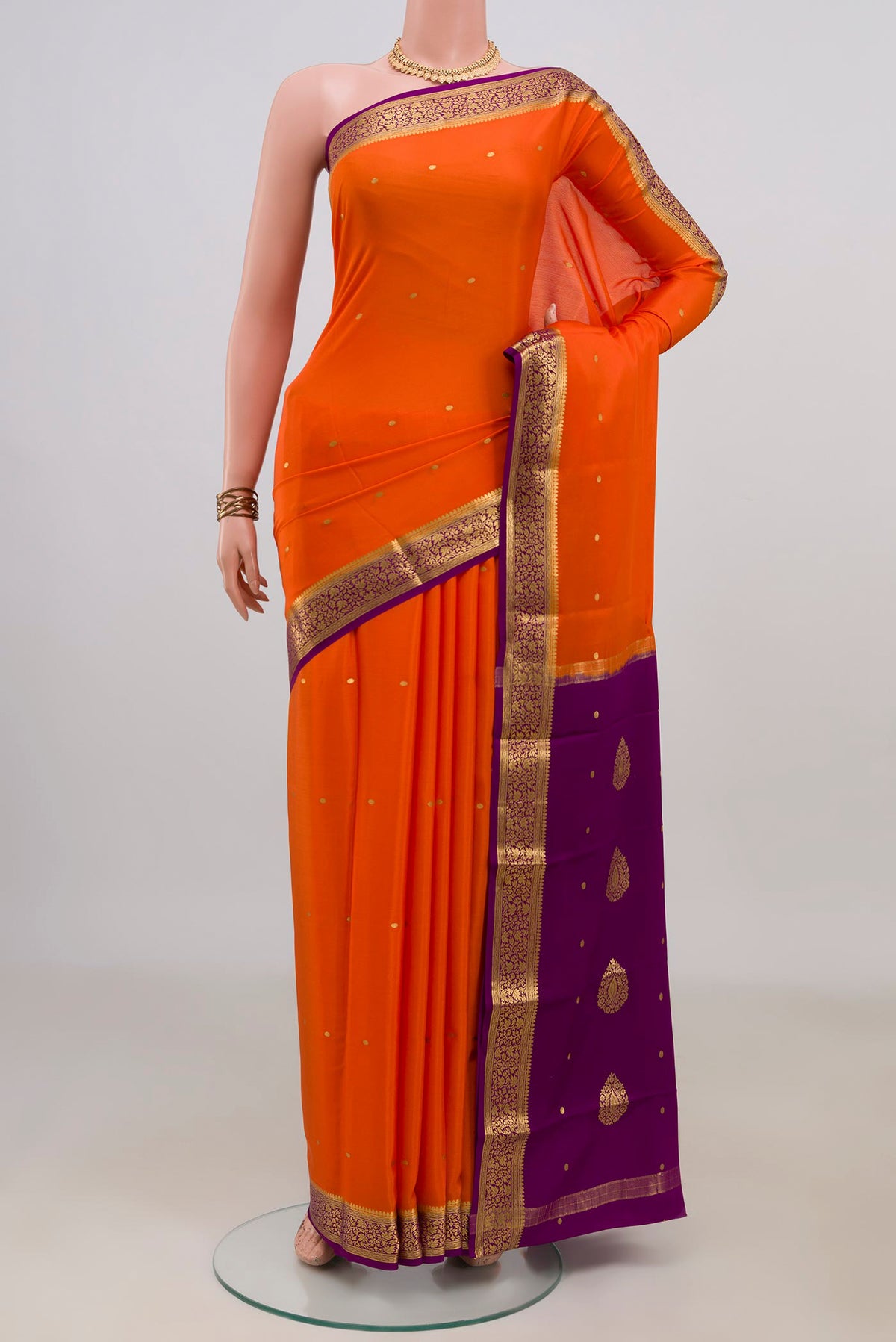 Orange Mysore Crepe Saree with Zari Butta on the body and Fancy Border.  displayed on a mannequin