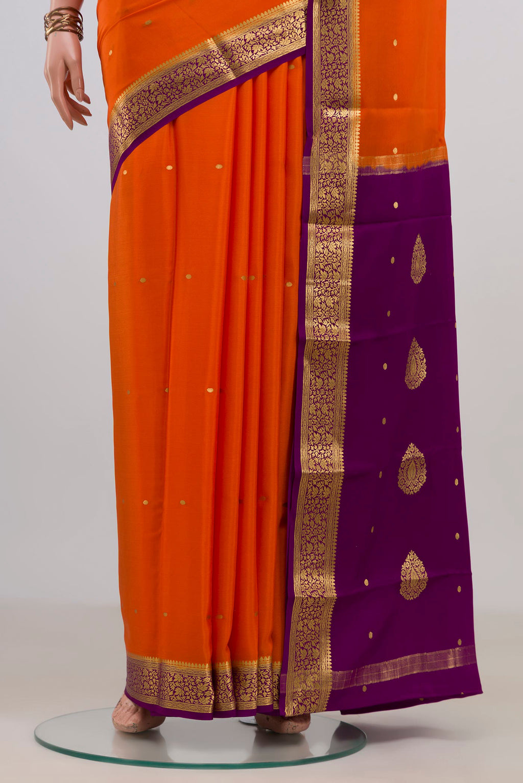 Pleats and pallu of Orange Mysore Crepe Saree with Zari Butta on the body and Fancy Border. 