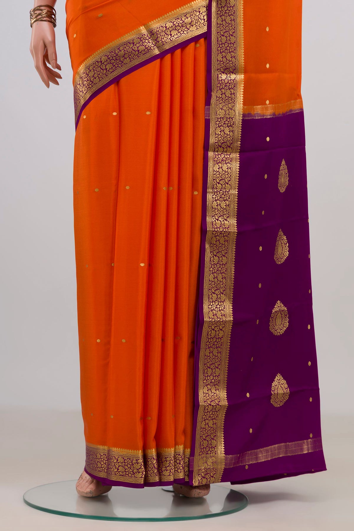 Pleats and pallu of Orange Mysore Crepe Saree with Zari Butta on the body and Fancy Border. 