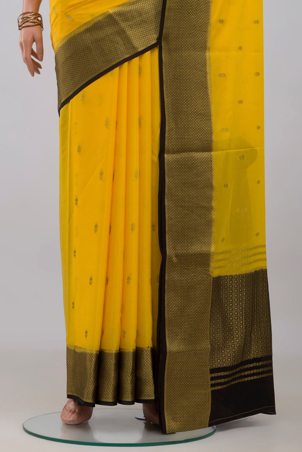 Pleats and pallu of Yellow Mysore Crepe Saree with Zari Butta on the body and Zari Border. 