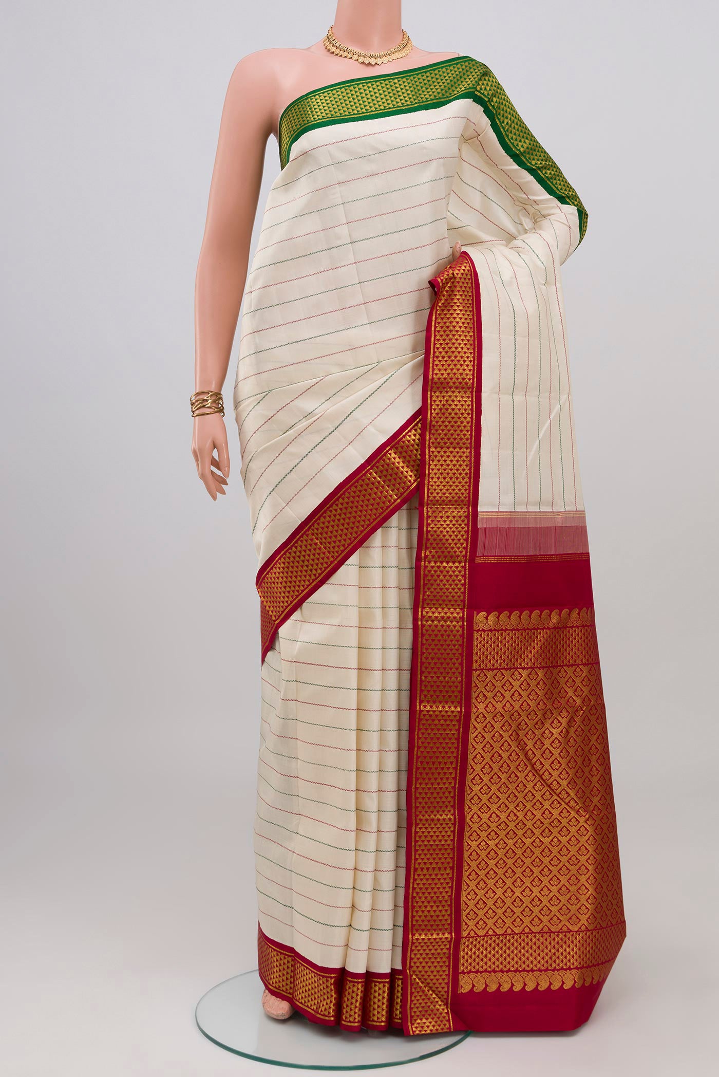 Off White Kanjivaram Silk Saree with Veldhari on the body and Ganga Jamuna Border.  displayed on a mannequin