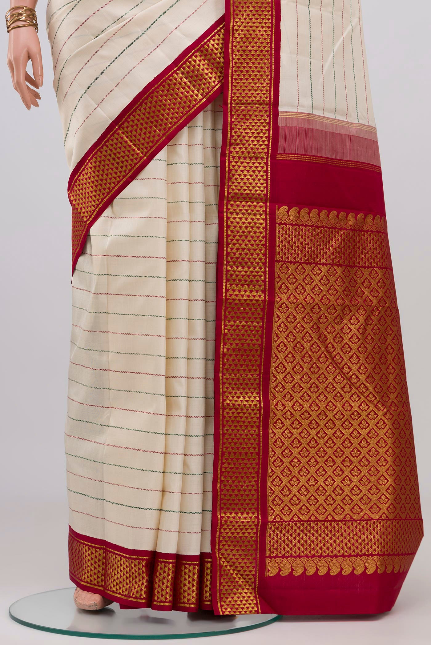 Pleats and pallu of Off White Kanjivaram Silk Saree with Veldhari on the body and Ganga Jamuna Border. 