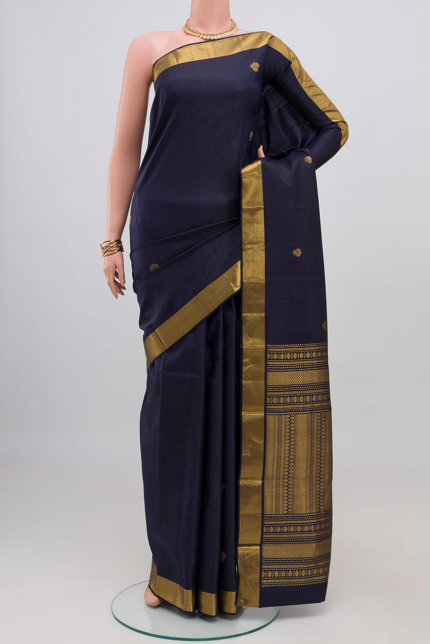 Navy Blue Kanjivaram Silk Saree with Zari Butta on the body and Zari Border.  displayed on a mannequin