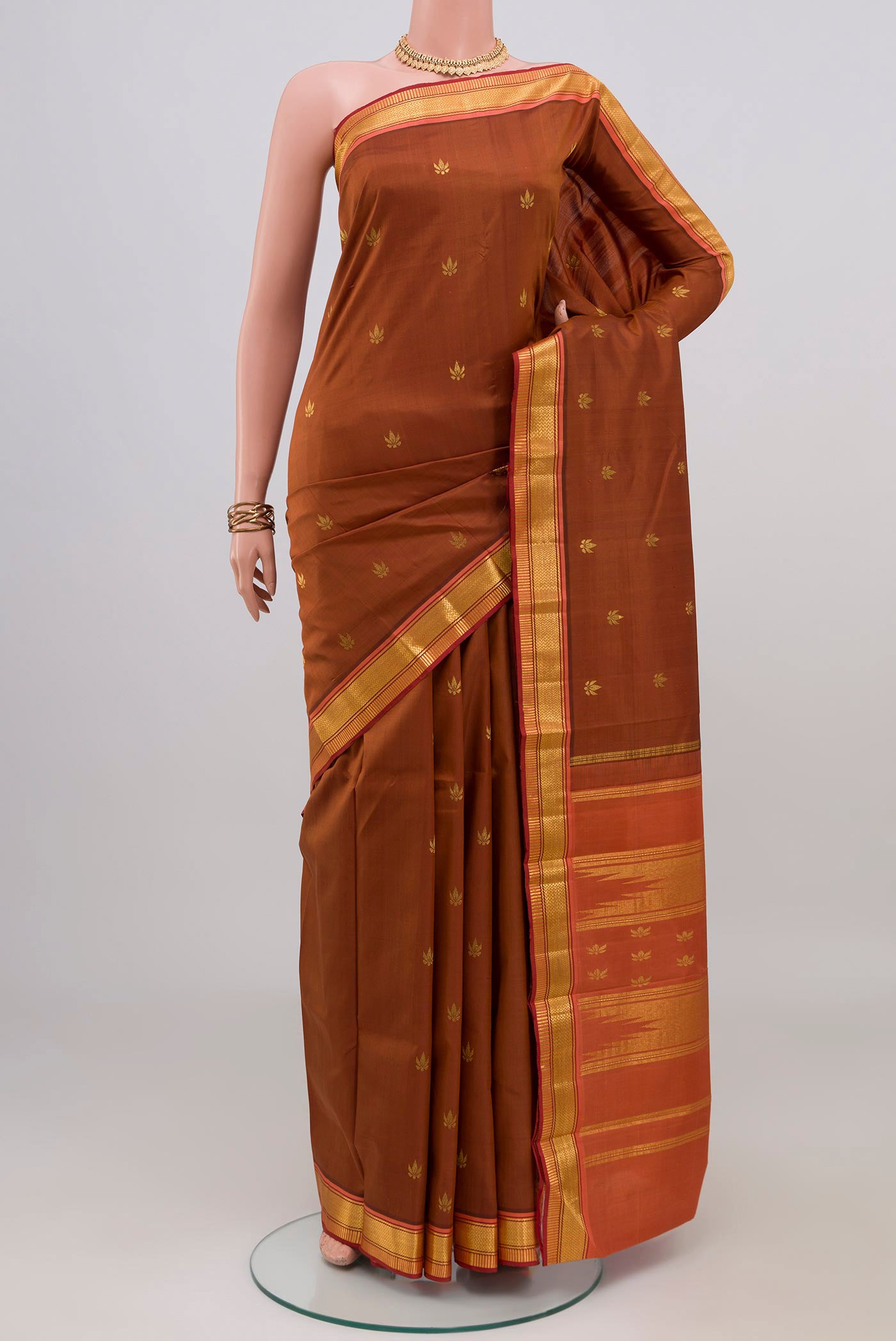 Brown Kanchipuram Silk Saree with Zari Butta on the body and Zari Border.  displayed on a mannequin