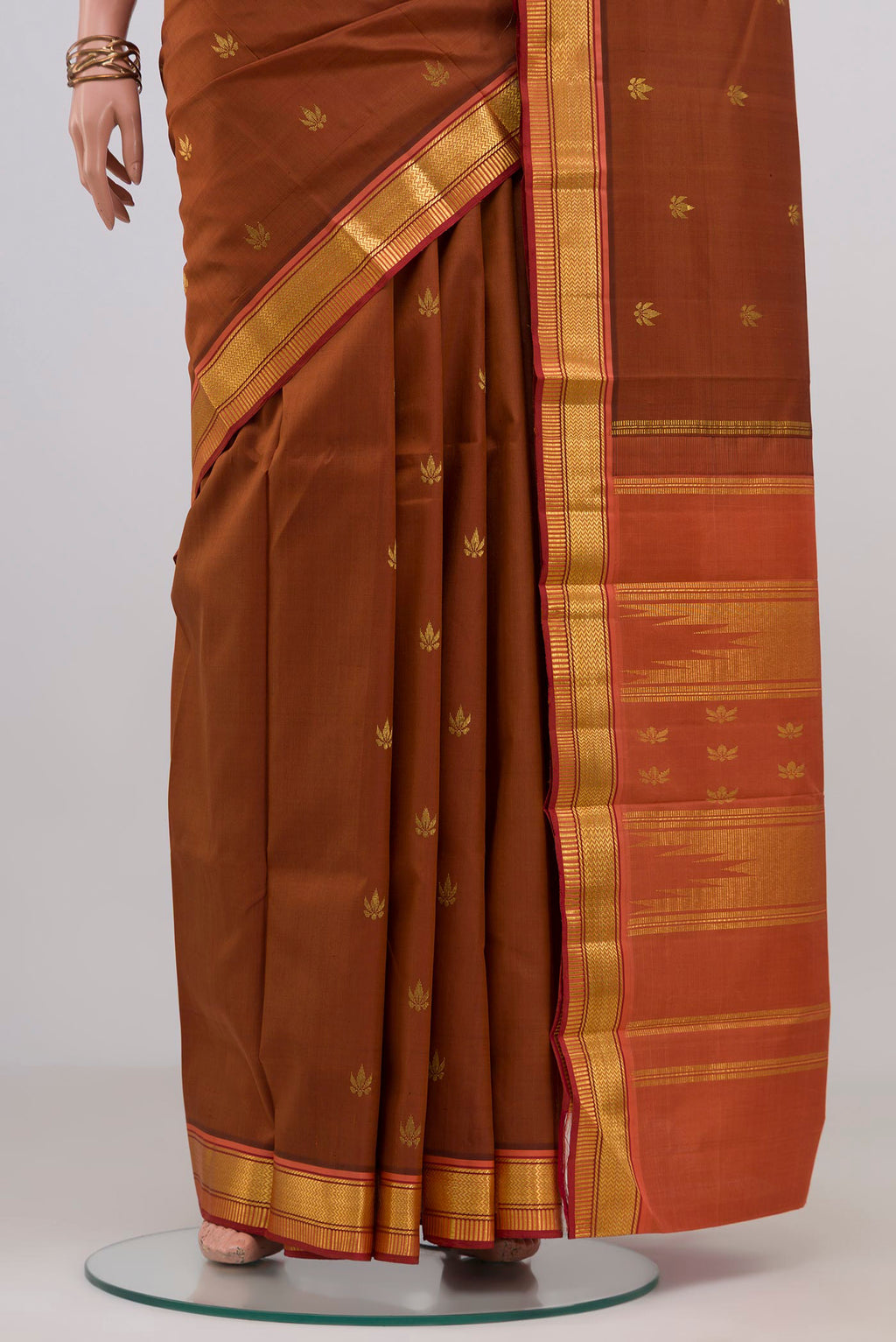 Pleats and pallu of Brown Kanchipuram Silk Saree with Zari Butta on the body and Zari Border. 