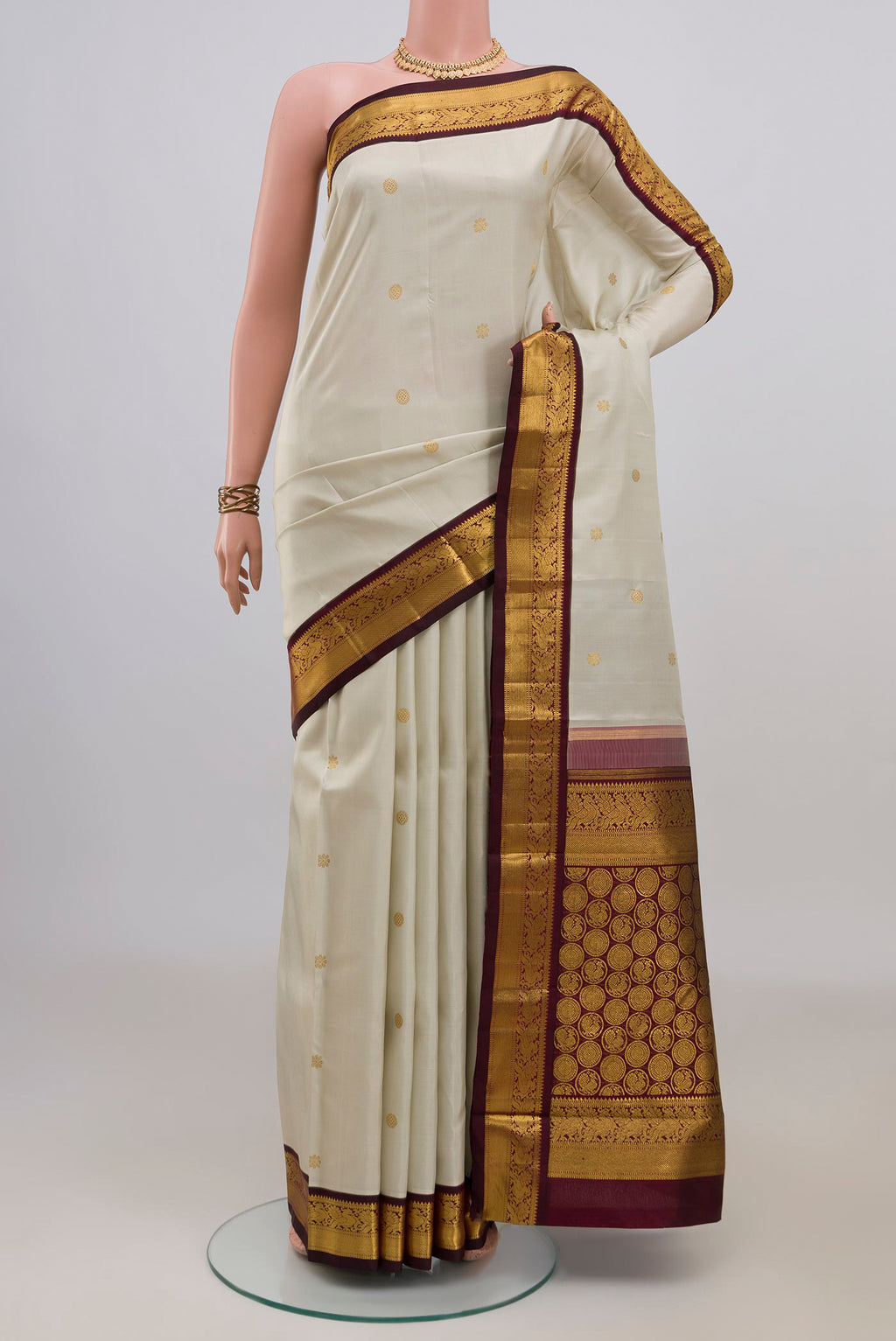 Pure Silk Pure Zari Cream Kanchipuram Saree with Zari Butta on the body and Zari Border.  displayed on a mannequin