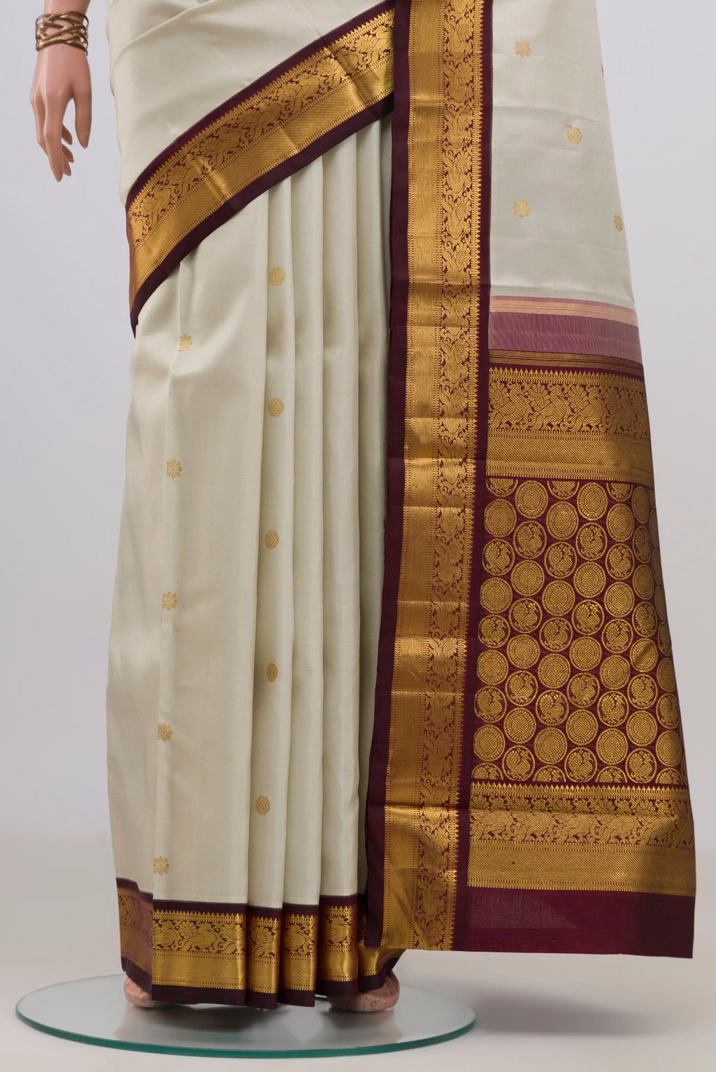 Pleats and pallu of Pure Silk Pure Zari Cream Kanchipuram Saree with Zari Butta on the body and Zari Border. 