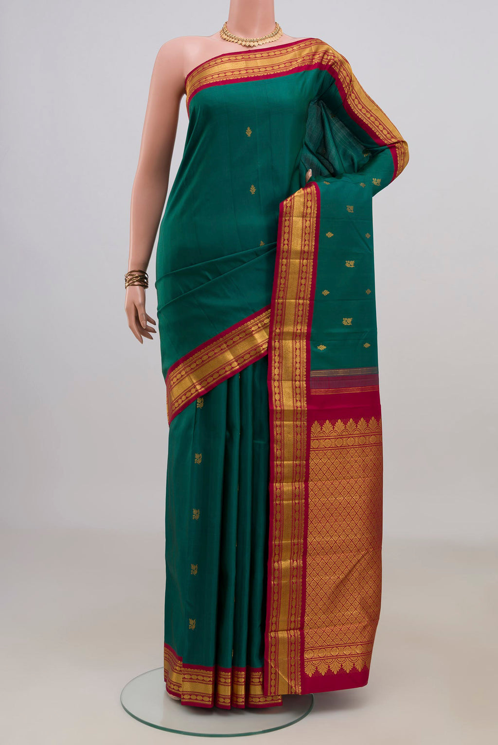 Pure Silk Green Kanchipuram Saree with Zari Butta on the body and Zari Border.  displayed on a mannequin