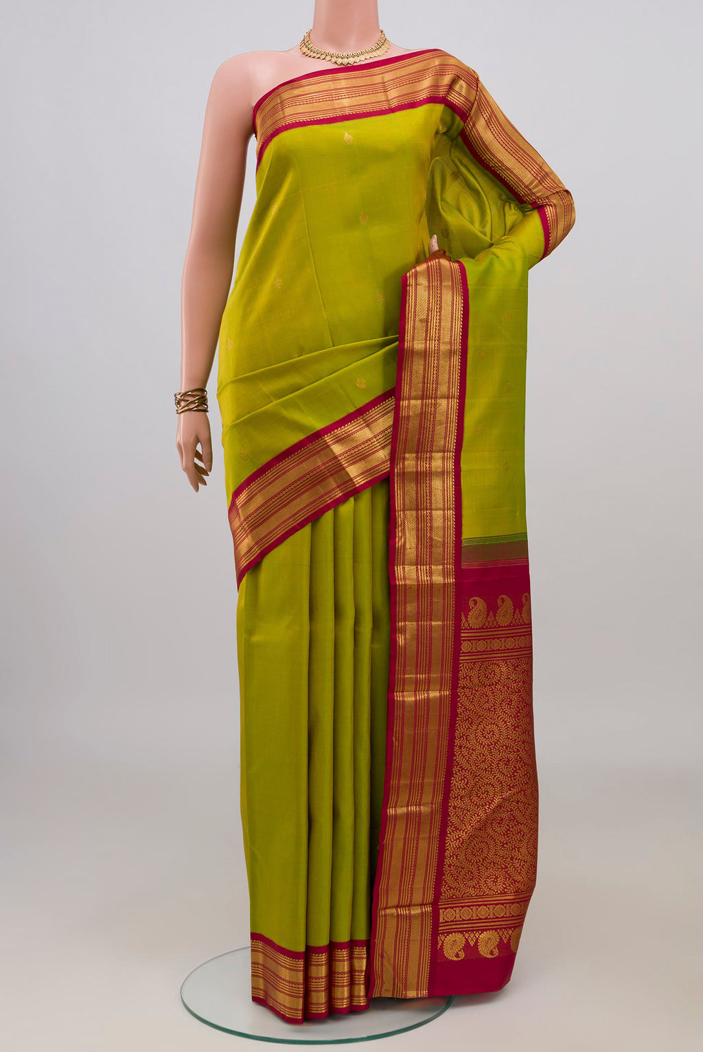 Pure Silk Green Kanchipuram Saree with Zari Butta on the body and Zari Border.  displayed on a mannequin