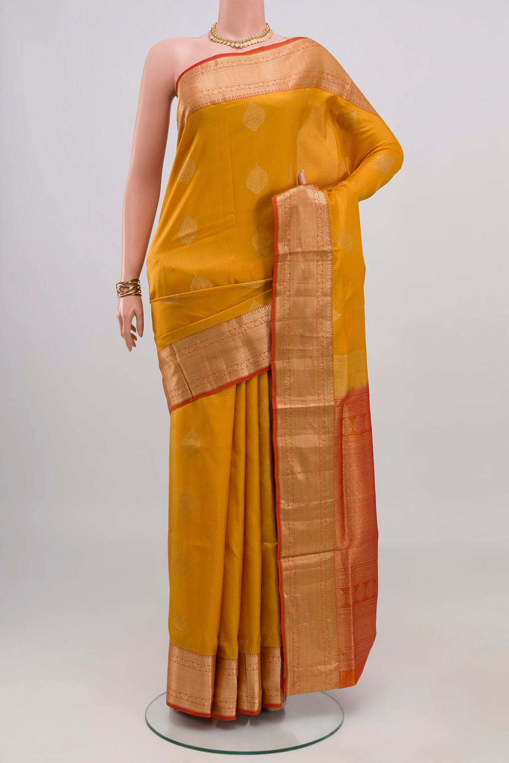 Mustard Soft Silk Saree with Zari Butta on the body and Zari Border.  displayed on a mannequin
