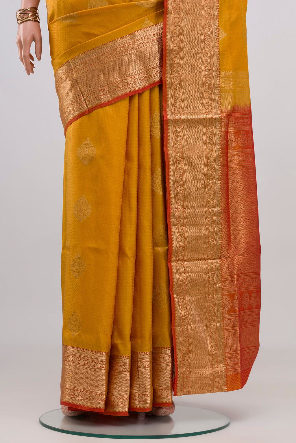 Pleats and pallu of Mustard Soft Silk Saree with Zari Butta on the body and Zari Border. 