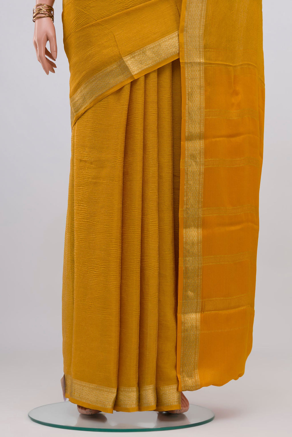 Pleats and pallu of Mustard Mysore Georgette Saree with Plain Body and Zari Border. 
