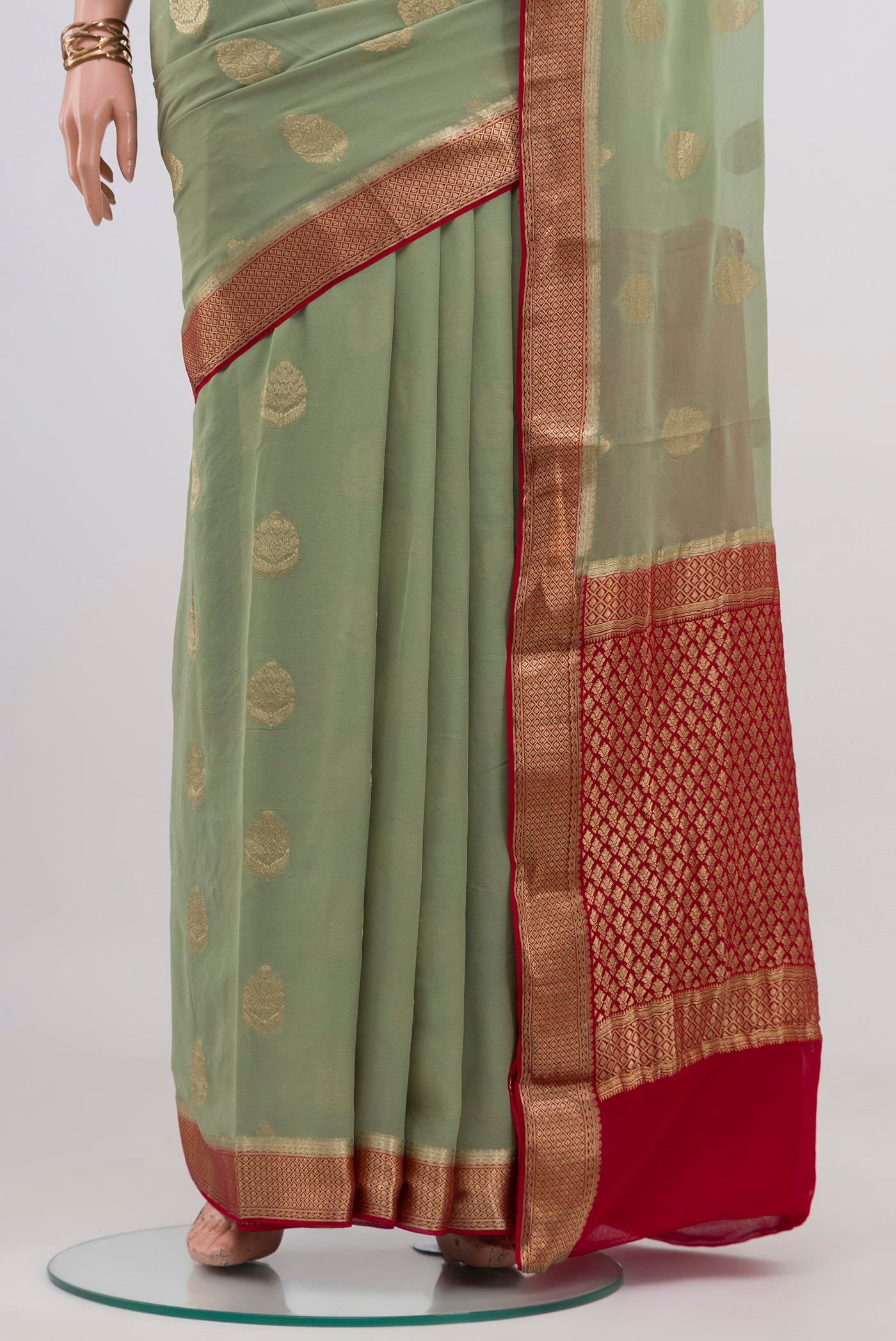 Pleats and pallu of Pista Green Mysore Georgette Saree with Zari Butta on the body and Zari Border. 