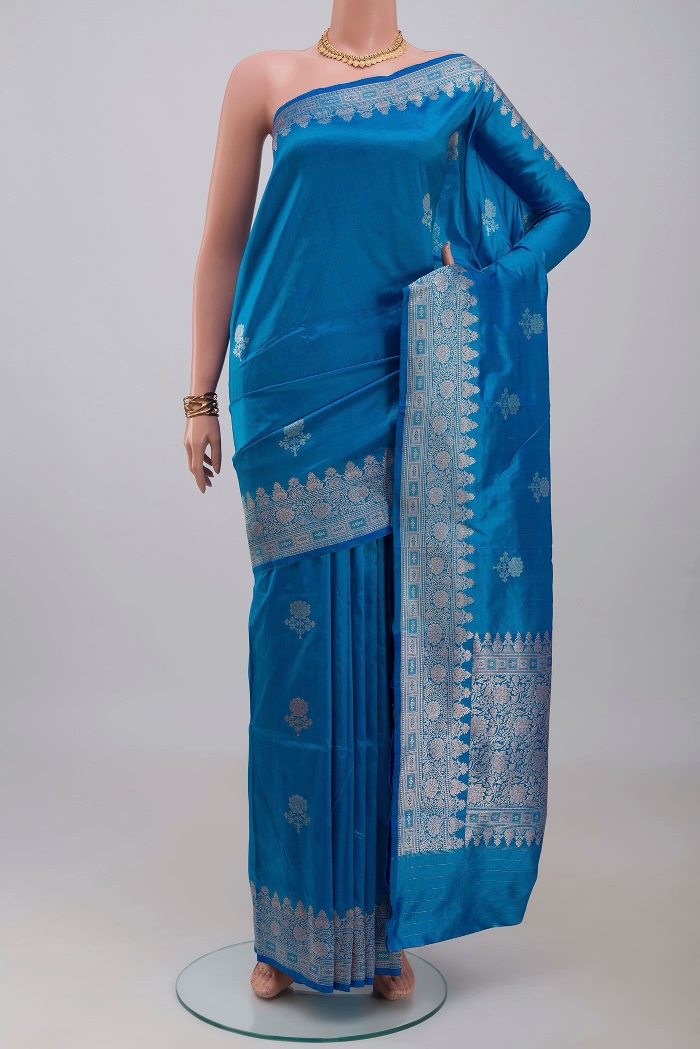 Blue Banarasi Katan Silk Saree with Zari Butta on the body and Zari Border.  displayed on a mannequin