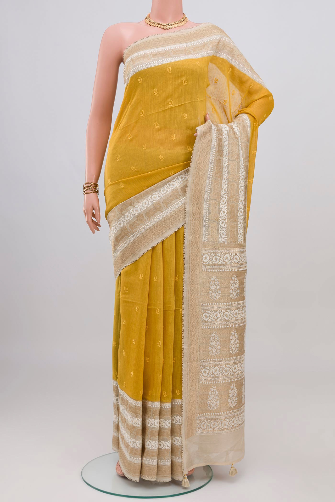 Yellow Tussar Silk Saree with Embroidery on the body and Fancy Border.  displayed on a mannequin