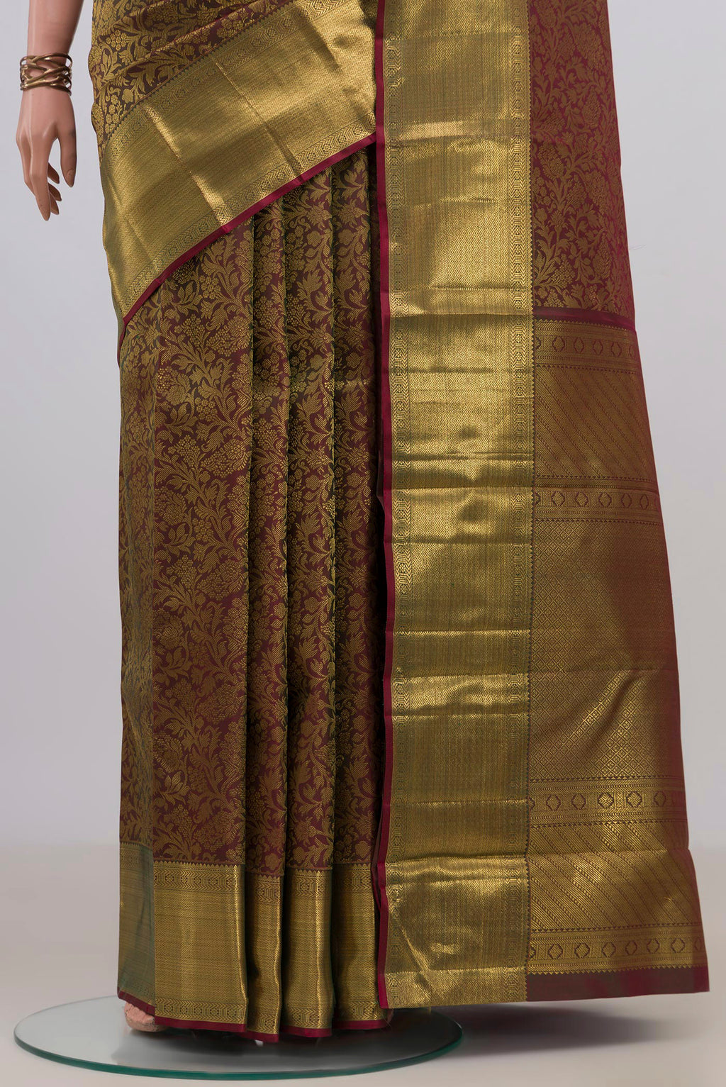 Pleats and pallu of Pure Silk Green with Brown Color Kanchipuram Saree with Zari Brocade on the body and Zari Border. 