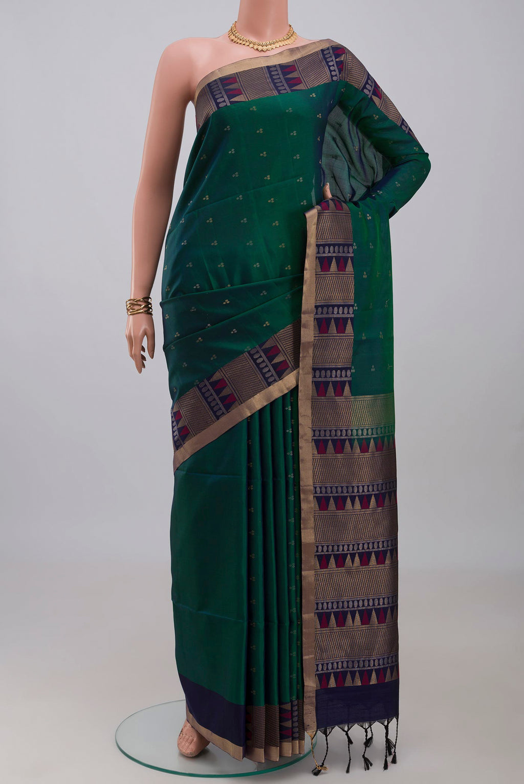 Green Soft Silk Saree with Zari Butta on the body and Fancy Border.  displayed on a mannequin
