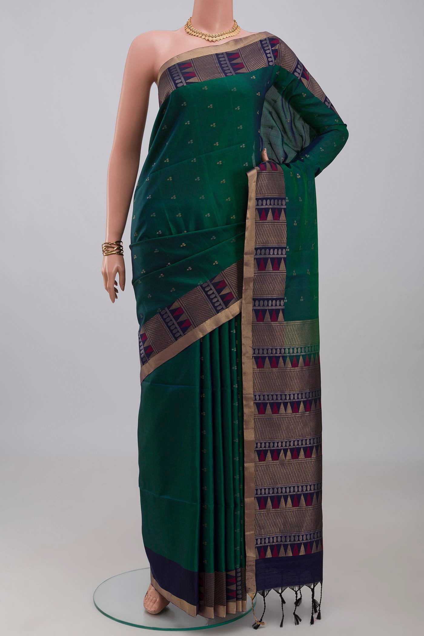 Green Soft Silk Saree with Zari Butta on the body and Fancy Border.  displayed on a mannequin