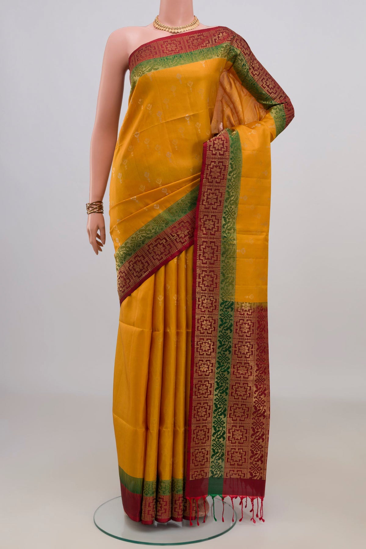 Pure Silk Mustard Soft Saree with Zari Butta on the body and Zari Border.  displayed on a mannequin