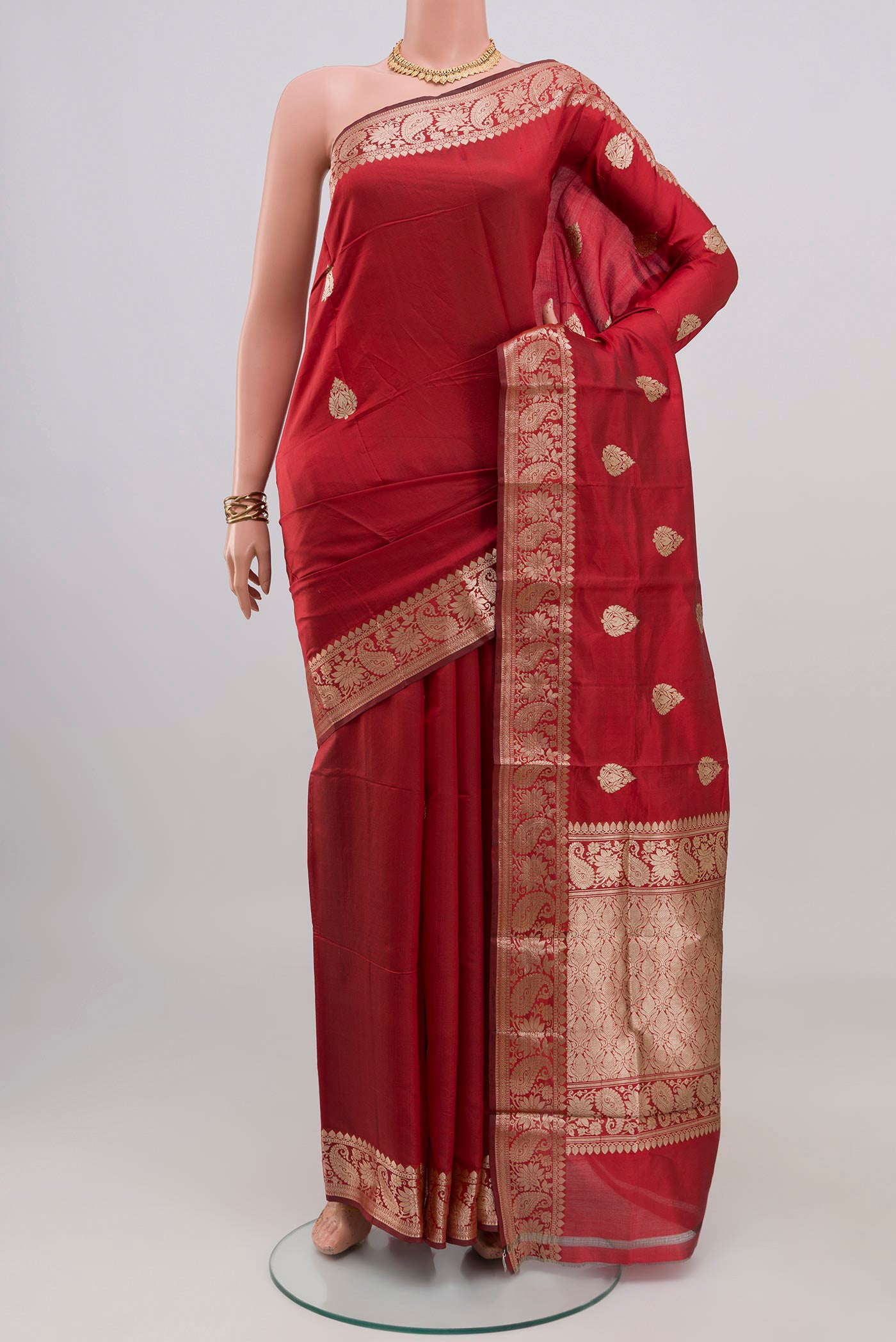 Maroon Banarasi Katan Silk Saree with Zari Butta on the body and Zari Border.  displayed on a mannequin