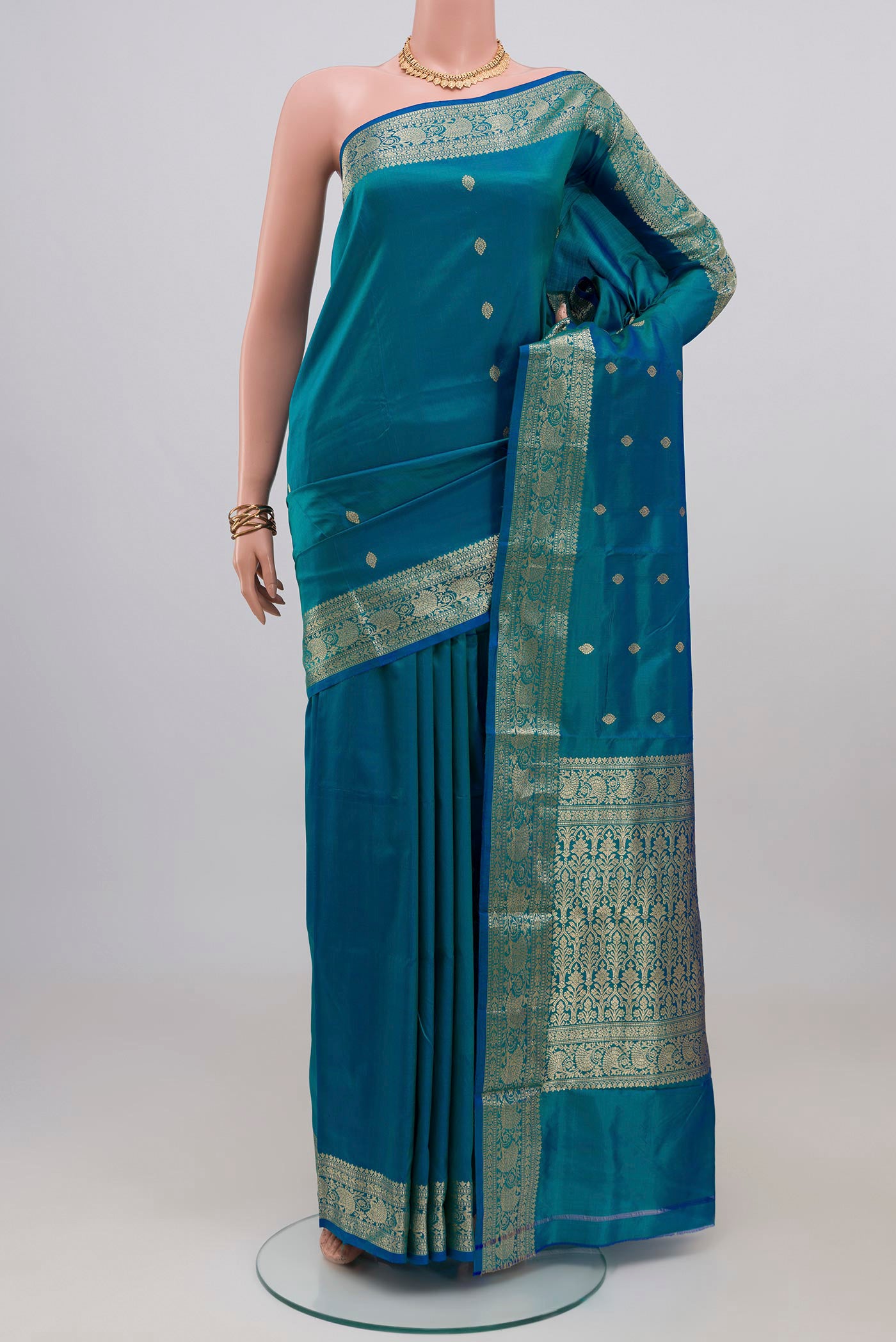 Blue Banarasi Katan Silk Saree with Zari Butta on the body and Zari Border.  displayed on a mannequin