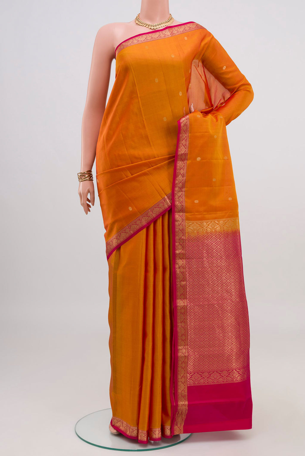 Mustard Kanchipuram Silk Saree with Zari Butta on the body and Zari Border.  displayed on a mannequin