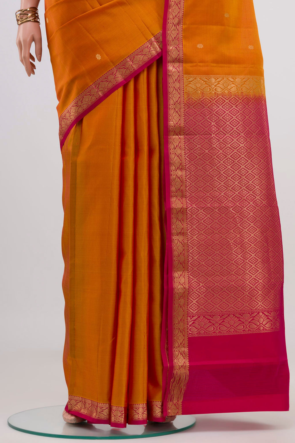 Pleats and pallu of Mustard Kanchipuram Silk Saree with Zari Butta on the body and Zari Border. 