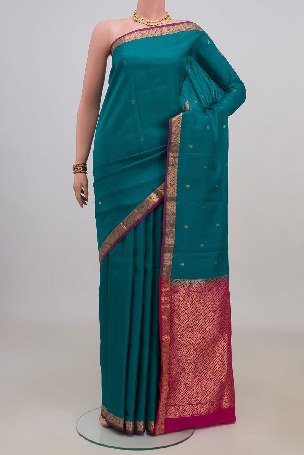 Pure Silk Teal Kanchipuram Saree with Zari Butta on the body and Zari Border.  displayed on a mannequin