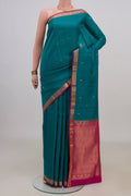 Pure Silk Teal Kanchipuram Saree with Zari Butta on the body and Zari Border.  displayed on a mannequin