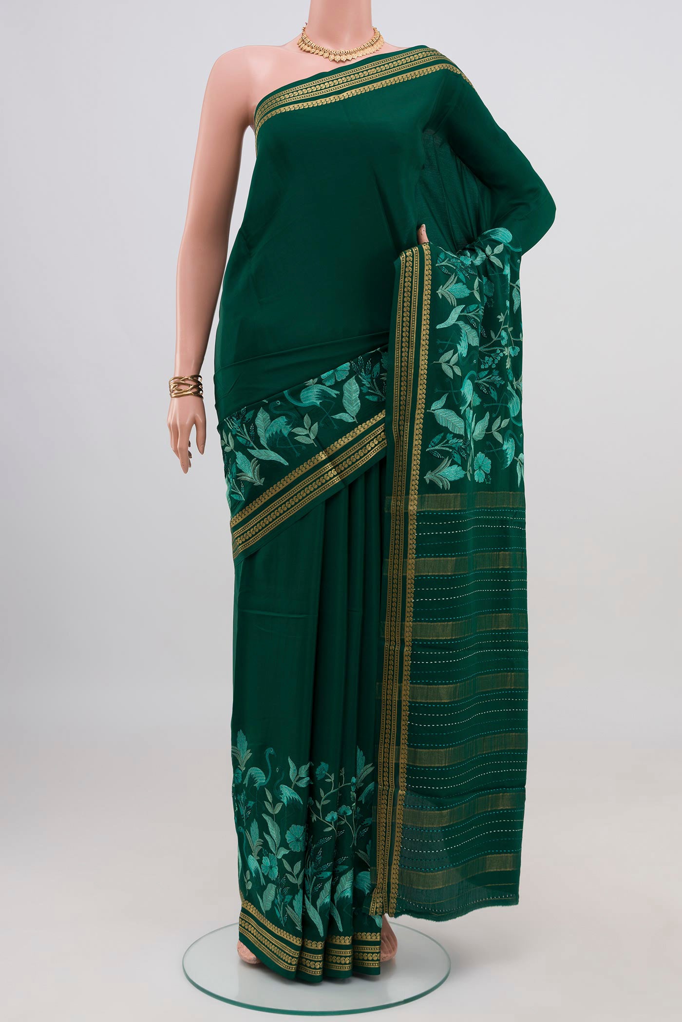 Green Crepe Saree with Fancy on the body and Fancy Border.  displayed on a mannequin