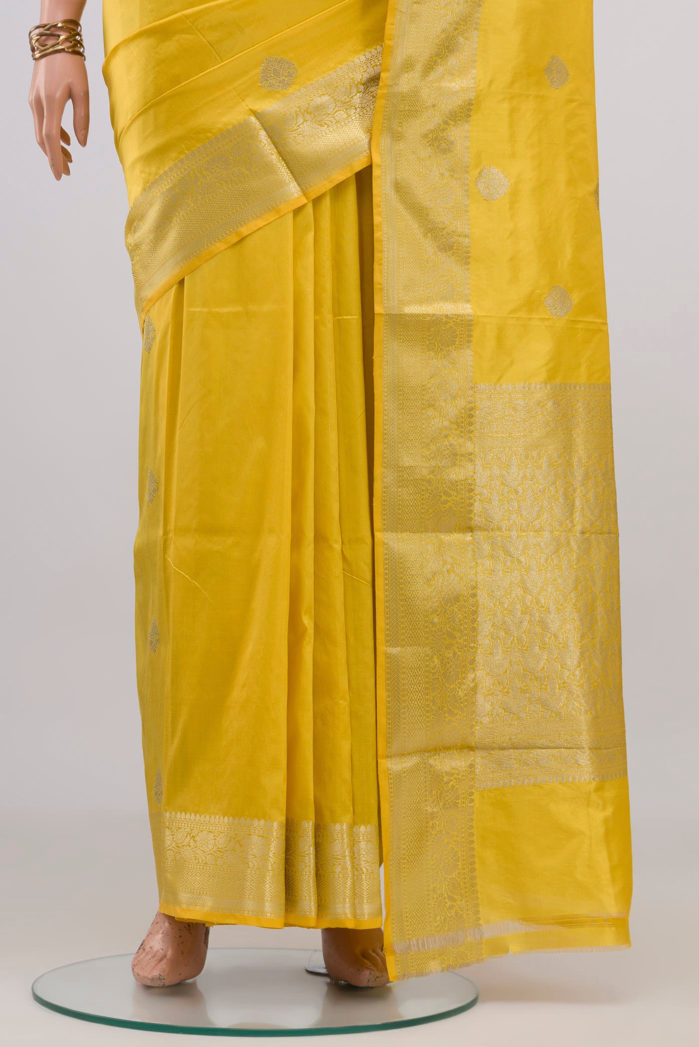 Pleats and pallu of Lemon Yellow Banarasi Katan Silk Saree with Zari Butta on the body and Zari Border. 