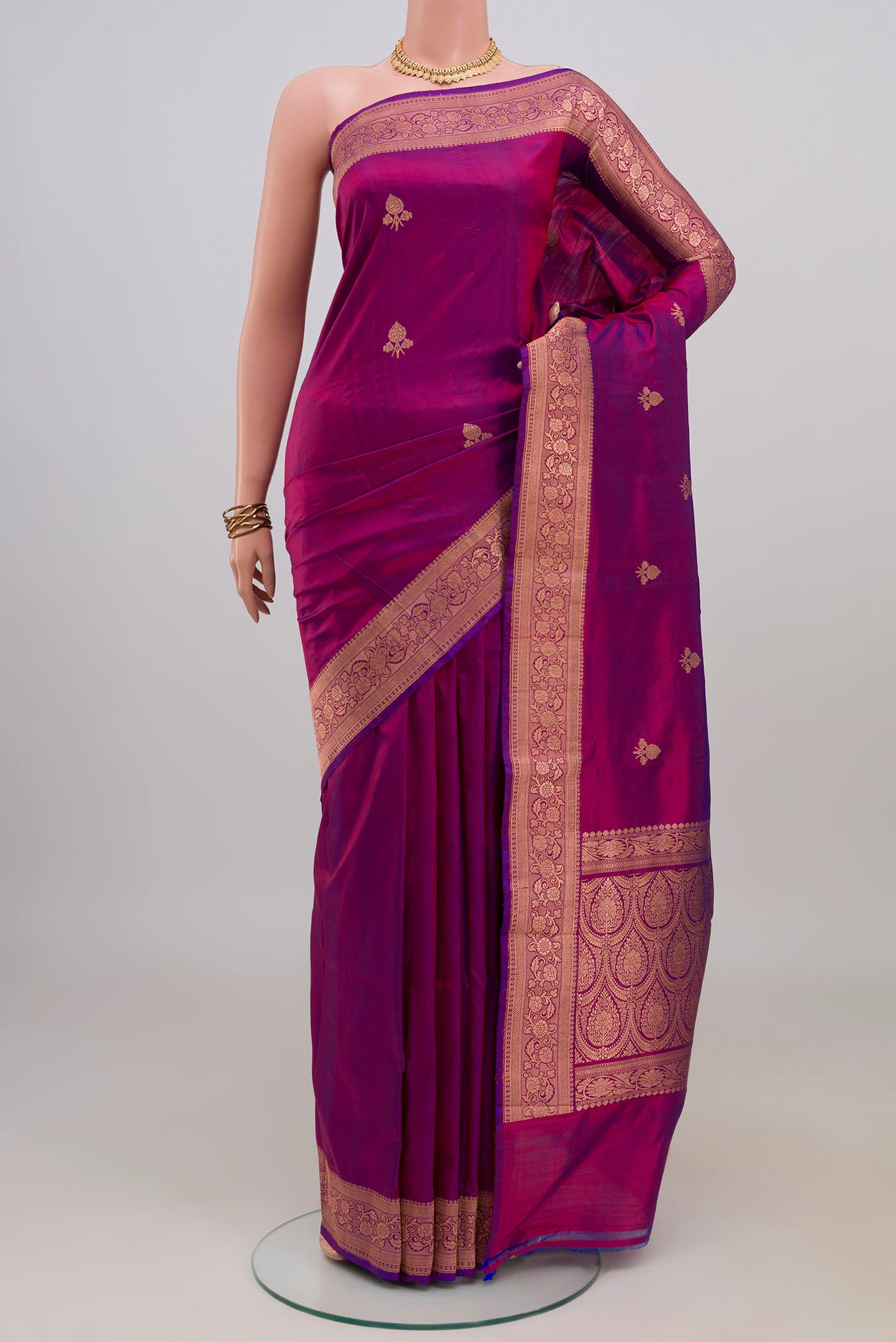 Magenta Banarasi Katan Silk Saree with Zari Butta on the body and Zari Border.  displayed on a mannequin