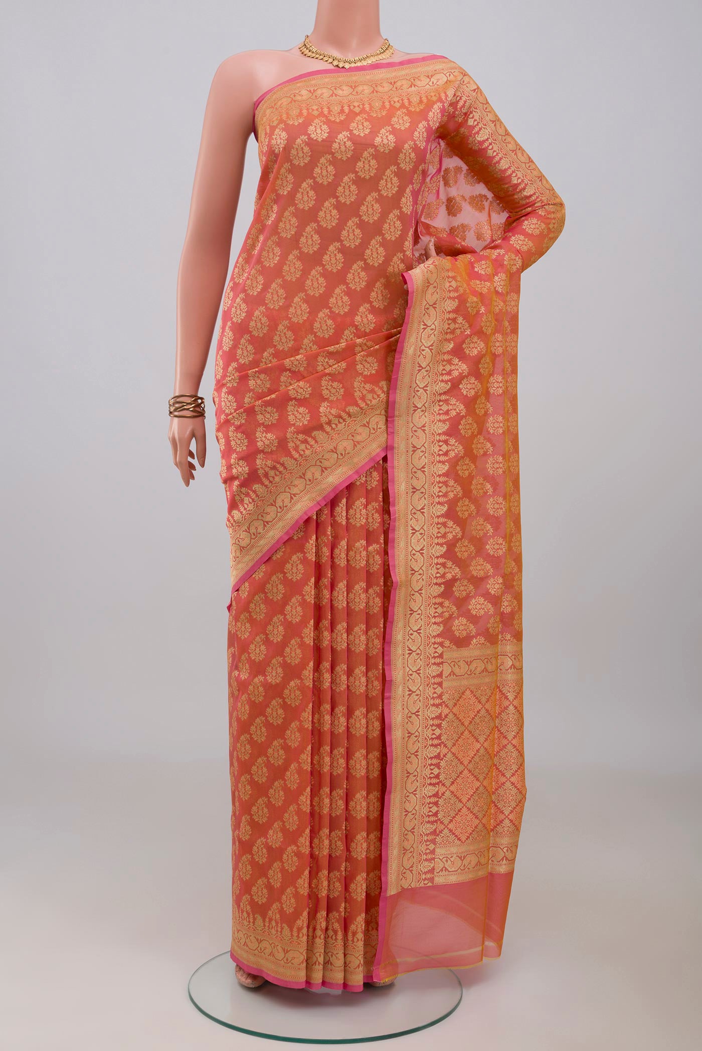 Peach Banarasi Silk Saree with Zari Butta on the body and Zari Border.  displayed on a mannequin