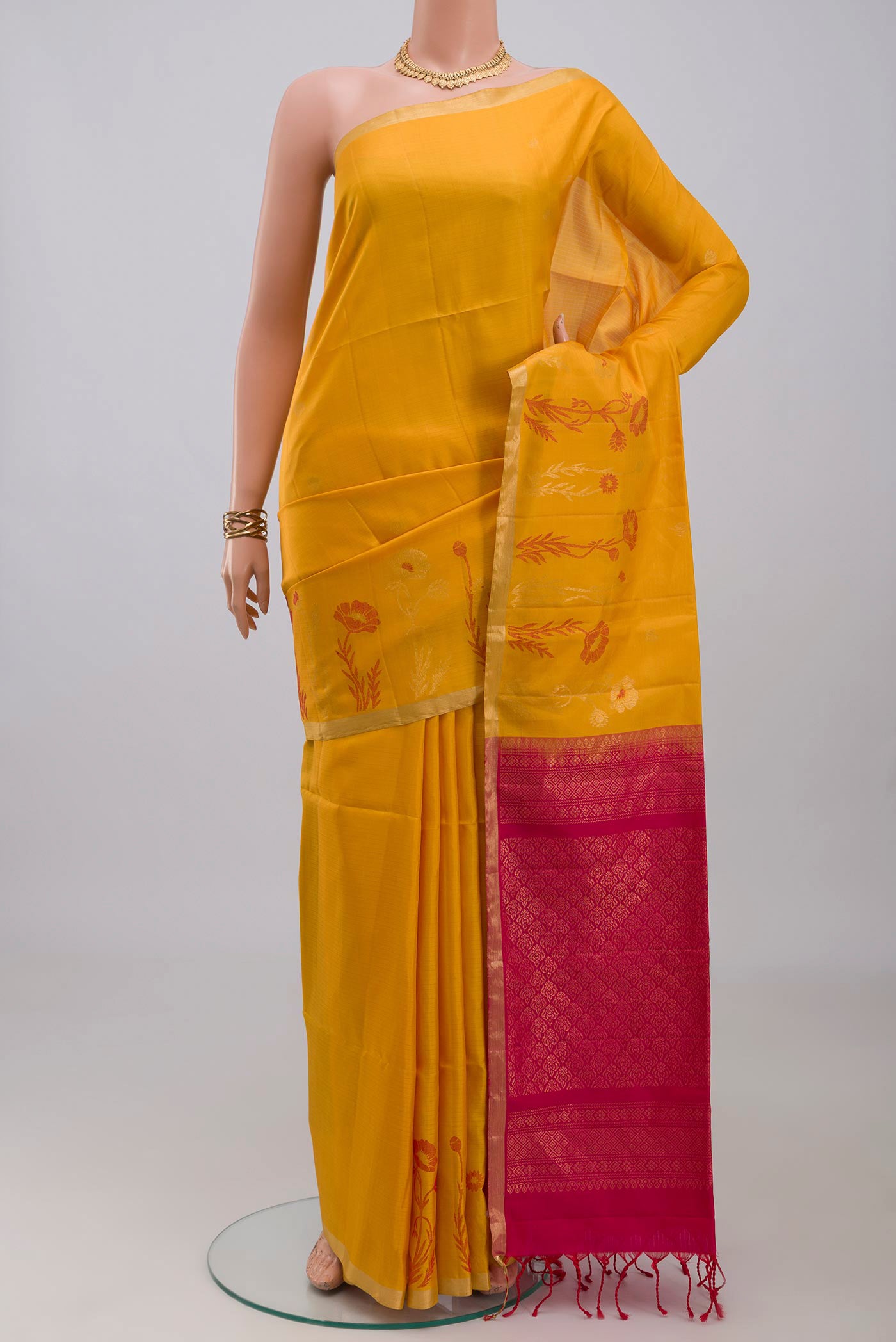 Yellow Soft Silk Saree with Zari Butta on the body and Fancy Border.  displayed on a mannequin