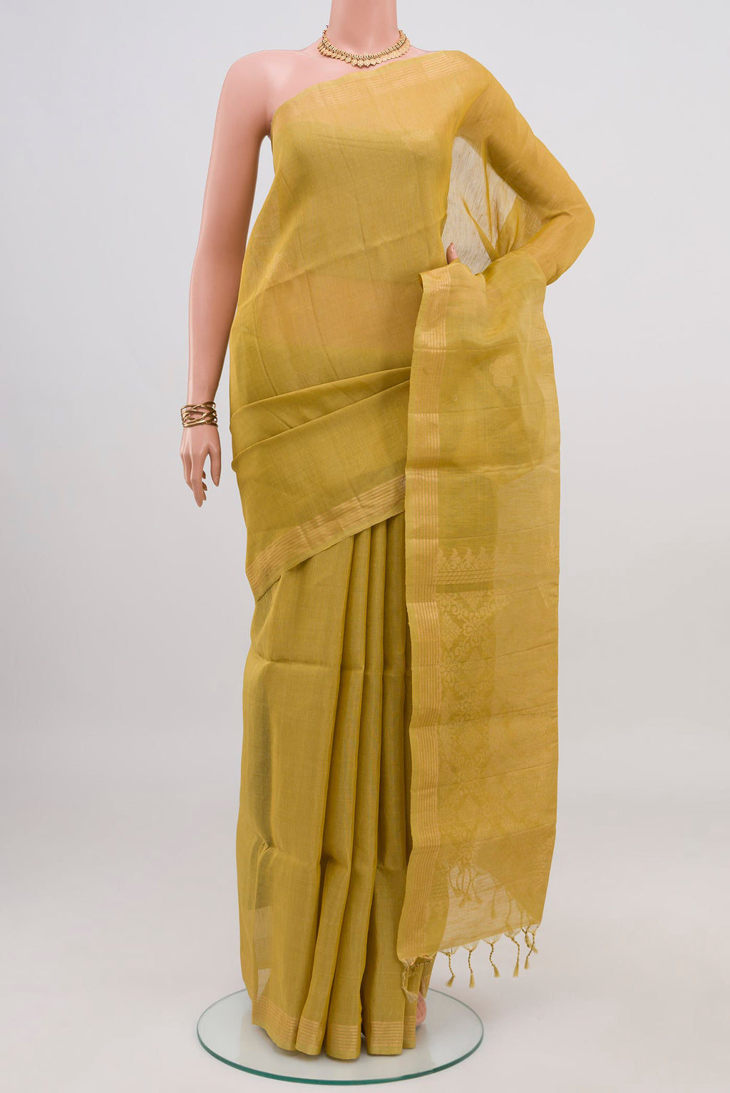 Green Soft Silk Saree with Zari Butta on the body and Thin Zari Line.  displayed on a mannequin