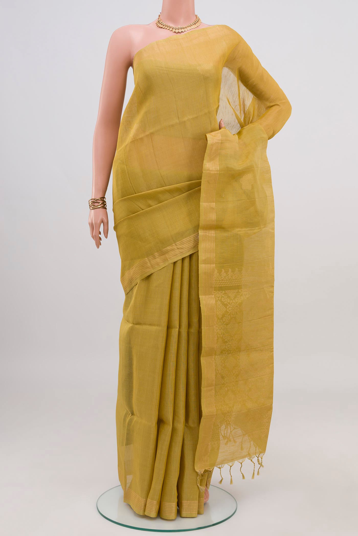 Green Soft Silk Saree with Zari Butta on the body and Thin Zari Line.  displayed on a mannequin