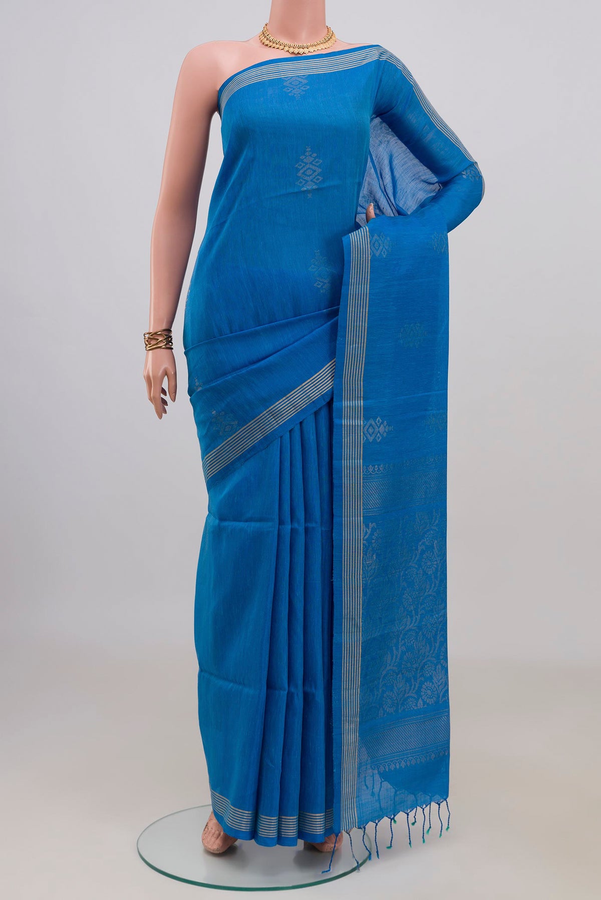 Pure Silk Blue Soft Saree with Zari Butta on the body and Thin Zari Line.  displayed on a mannequin