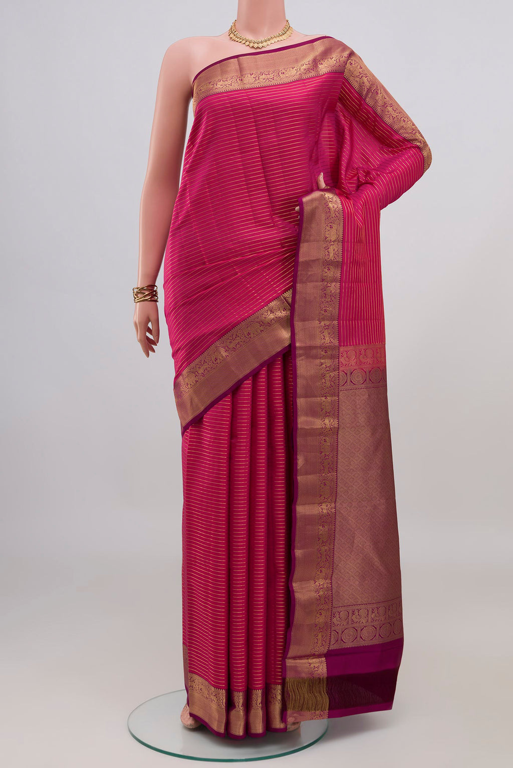 Pink Kanjivaram Silk Saree with Stripes on the body and Zari Border.  displayed on a mannequin