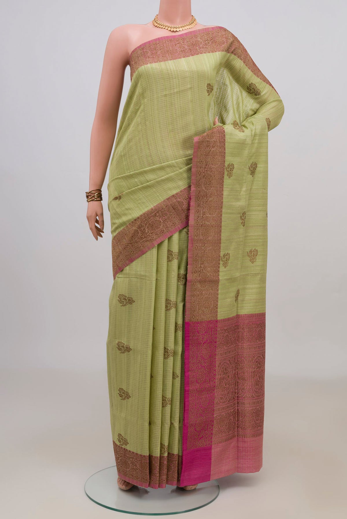 Pure Silk Light Green Banarasi Tussar Saree with Zari Butta on the body and Fancy Border.  displayed on a mannequin