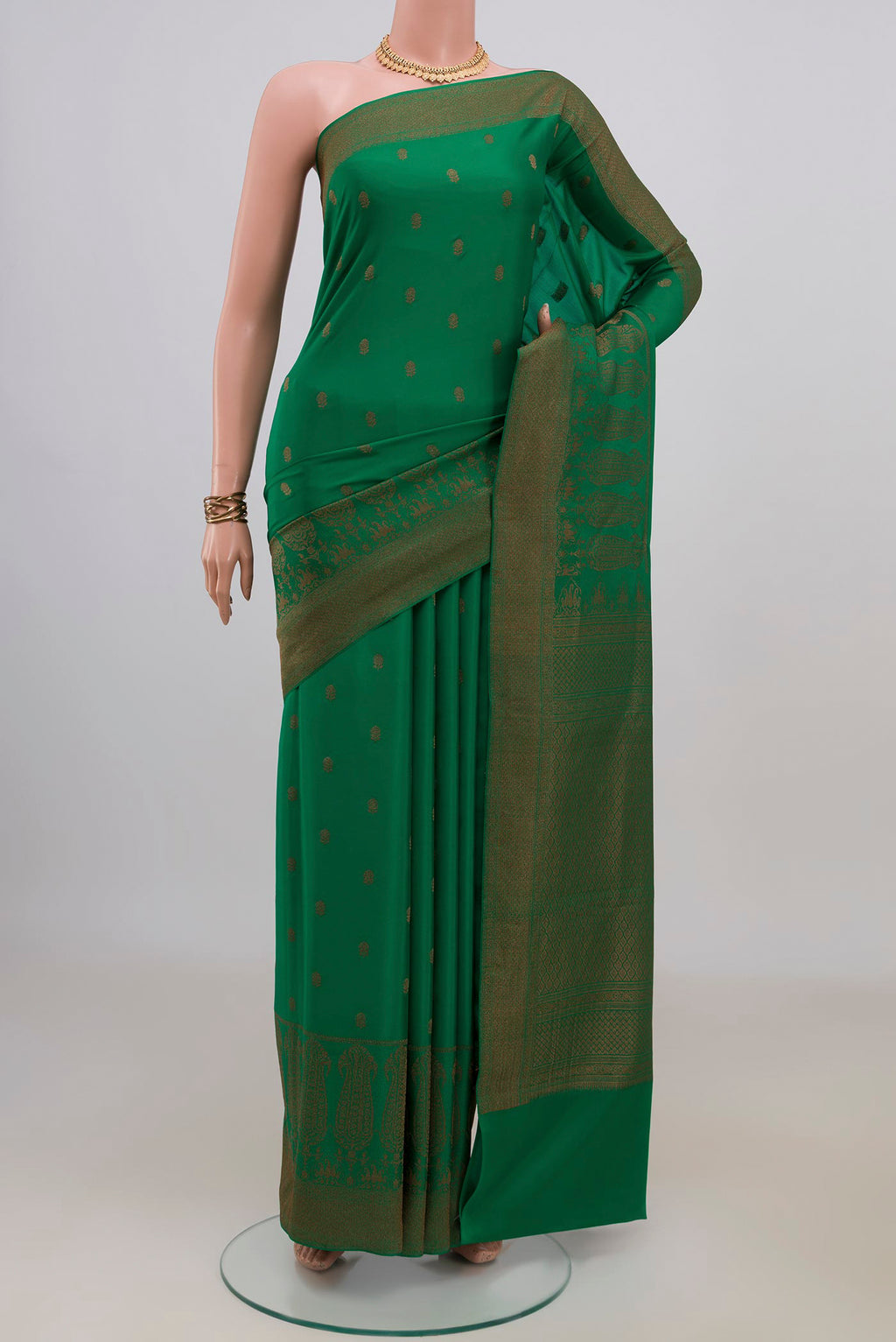 Green Crepe Saree with Zari Butta on the body and Fancy Border.  displayed on a mannequin
