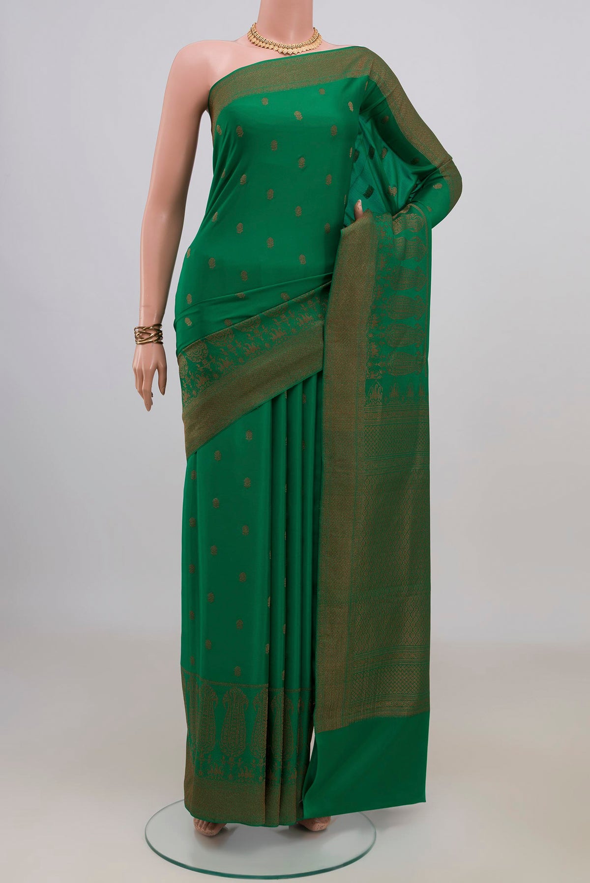 Green Crepe Saree with Zari Butta on the body and Fancy Border.  displayed on a mannequin