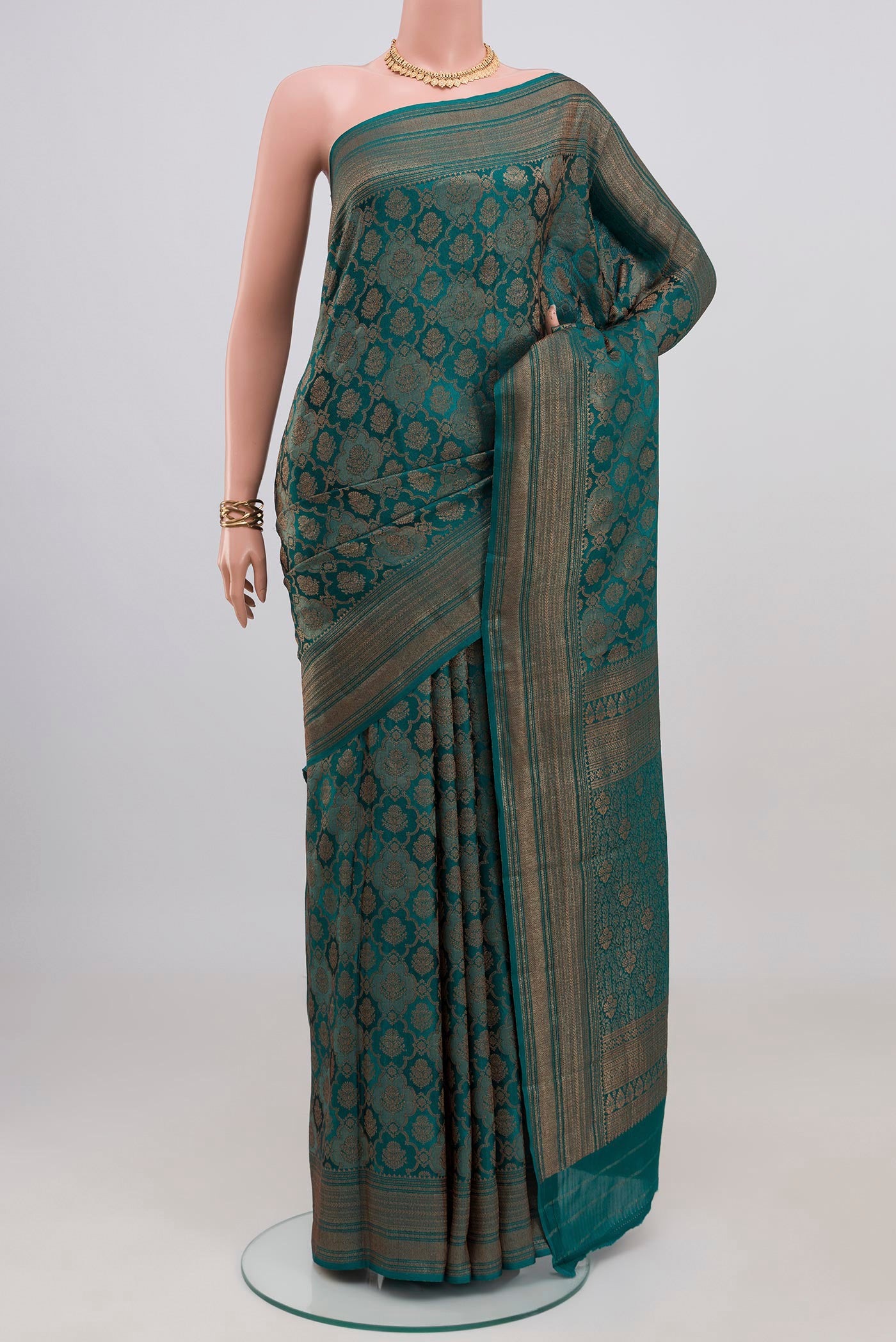 Teal Crepe Saree with Zari Brocade on the body and Zari Border.  displayed on a mannequin