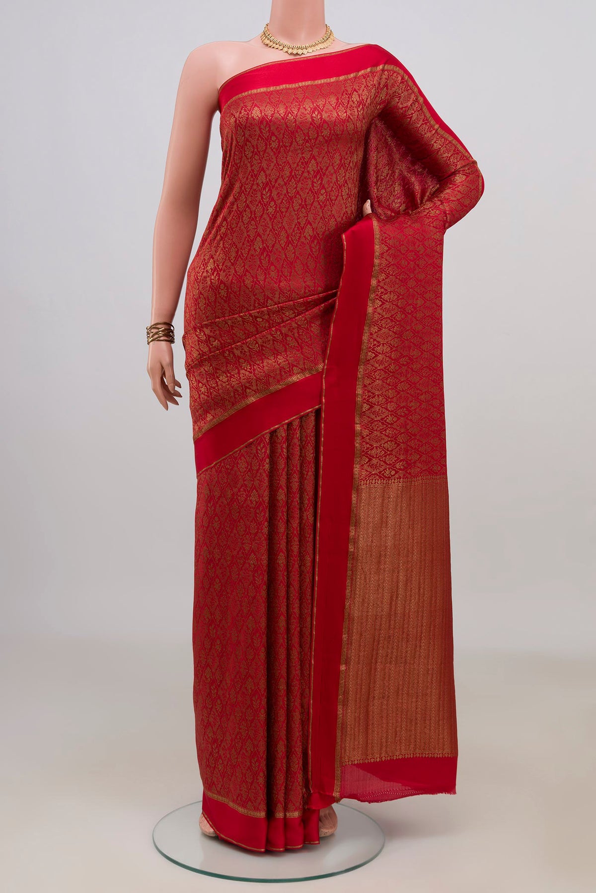 Red Crepe Saree with Zari Brocade on the body and Thin Zari Line.  displayed on a mannequin