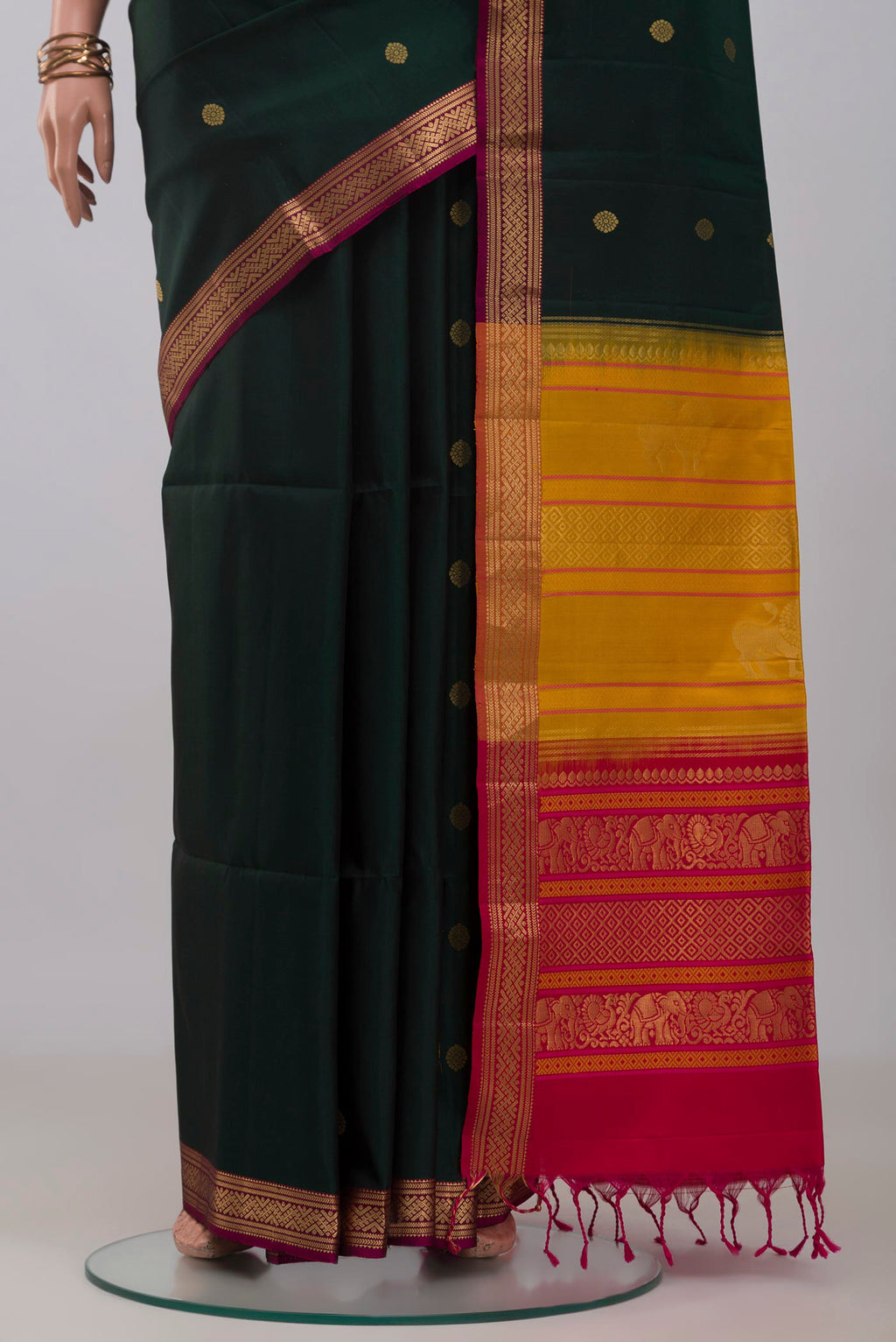 Pleats and pallu of Bottle Green Soft Silk Saree with Zari Butta on the body and Zari Border. 