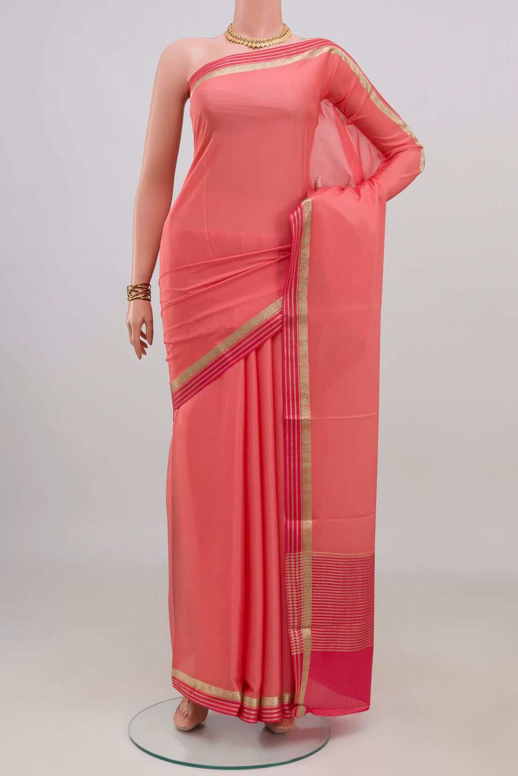 Peach Mysore Crepe Saree with Plain Body and Thin Zari Line.  displayed on a mannequin