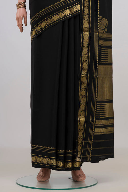Pleats and pallu of Black Crepe Saree with Plain Body and Zari Border. 